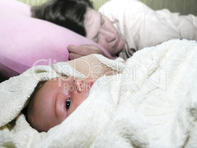 newborn baby and her tired sleeping mother