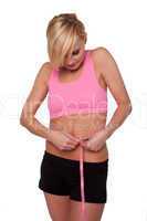 Sporty woman measuring her waist