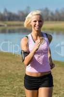 Young woman jogging in park sunny day