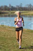 Young woman jogging river park sunny day