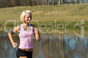 Young woman jogging lake park sunny day