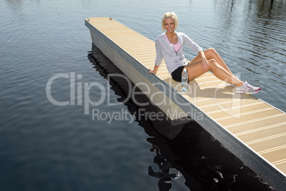 Young sport woman relax on pier lake