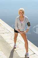Sport woman stretching legs on a dock