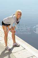 Sport woman stretching legs on a dock