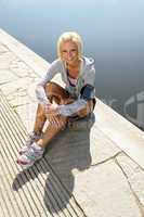Sport woman relax on pier sitting water