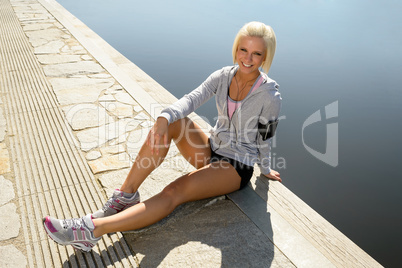Sport woman relax on pier by lake