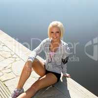 Sport woman relax on pier sitting water
