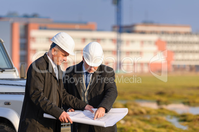 Two architects man look at construction plan