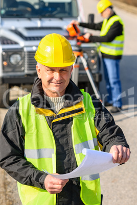 Land geodesist man hold plan reflective vest