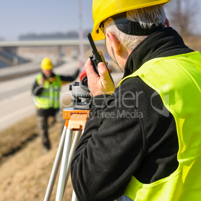 Geodesist measure land with tacheometer highway