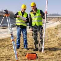 Geodesist two man theodolite stand highway