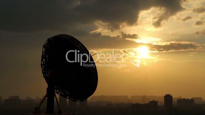 rotating radio telescope at sunset