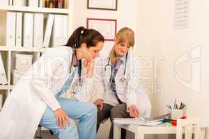 Two female doctor discussing document