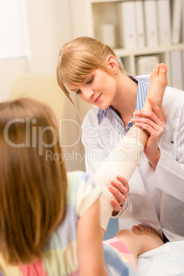Pediatrician checking broken bandage girl leg