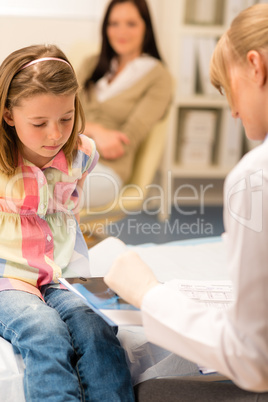 At pediatrician office girl look medical document