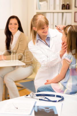 Pediatrician checking eye girl at medical office