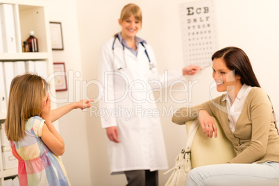Girl reading eye chart pediatrician office