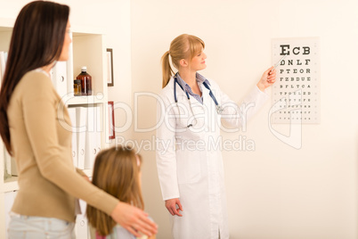 Pediatrician pointing eye-chart at medical office