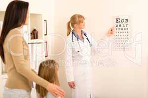 Pediatrician pointing eye-chart at medical office