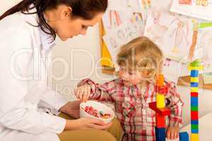 Pediatrician give lolly to little child girl