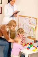 Pediatrician female review children play activity