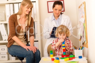 Pediatrician mother daughter playing at office