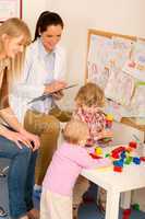 Pediatrician female review children play activity