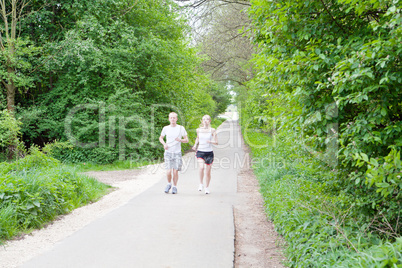 young couple is jogging in the forest