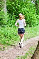 young woman is jogging in forest