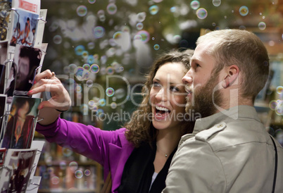 Young couple shopping for a post card.