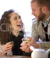 Young couple drinking tea and laughing.