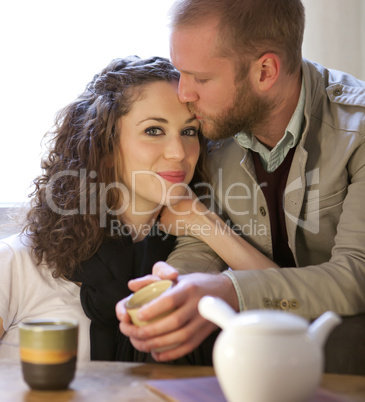 Couple is drinking tea in the living room.