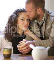 Couple is drinking tea in the living room.