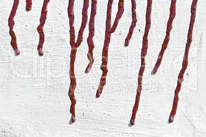streaks of red paint on the whitewashed wall