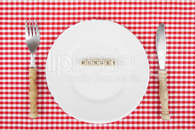 White plate with Hungry-lettering and cutlery