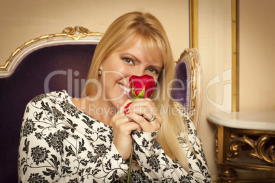 Seated Woman Smiling While Smelling Red Rose