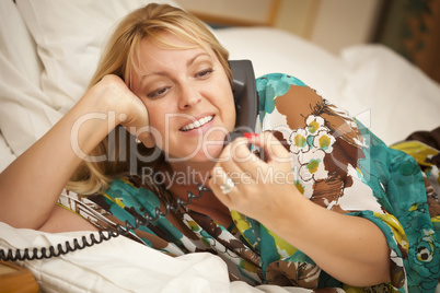 Woman Laying on Her Bed Using the Telephone