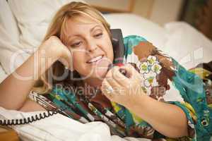 Woman Laying on Her Bed Using the Telephone