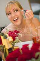Blonde Woman Applies Makeup at Mirror Near Champagne and Roses