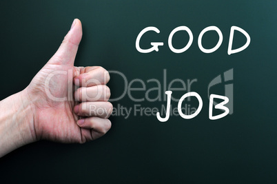 Thumb up with good job written on a blackboard