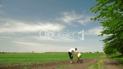 Father Helping Toddler Ride Bicycle