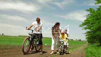 Family Cycling Outdoors In Summer