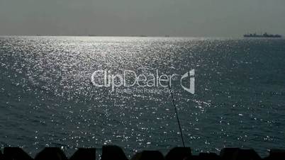 Sparkling water surface and fishing rod,horizon,skyline,Vessel Ship.