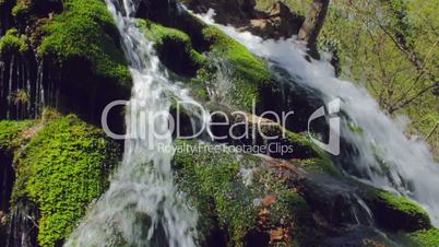 Waterfall in spring forest. Shot with slider. Slow-motion.