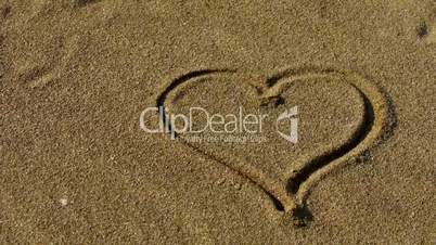 heart on golden sandy beach,wind blow sand.
