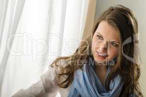 Young woman look down window behind curtain