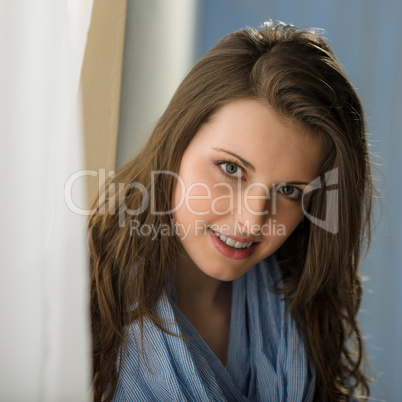 Young woman brunette look camera behind curtain