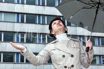 Woman with umbrella check whether it's raining