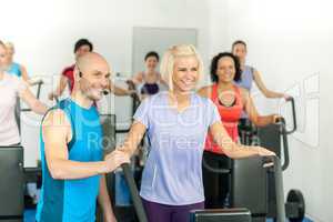Fitness instructor leading gym people exercise