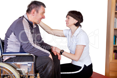 Frau spricht Mann im Rollstuhl Trost zu